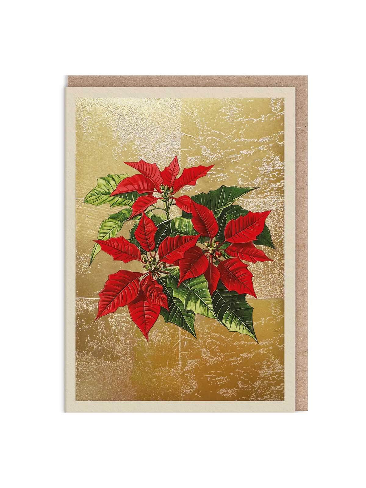 A rectangular greeting card featuring a red poinsettia plant illustration on a textured gold background, with a beige border and a matching beige envelope behind it.
