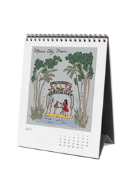Desk calendar with illustration of palm trees and people on a lake, featuring the month of July.
