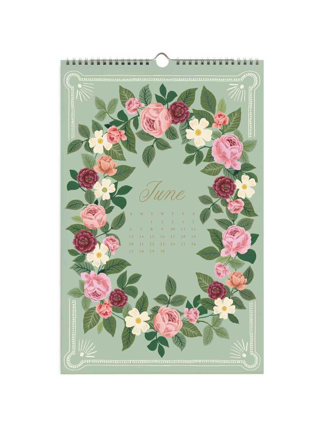 A hanging wall calendar page for June with a floral wreath design in pink, burgundy, cream, and green on a pale sage background. The word 'June' is printed in the center, with a small calendar grid below it.