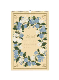 A vintage-style hanging calendar page for March, featuring a cream background decorated with a border of blue and white flowers and green leaves.