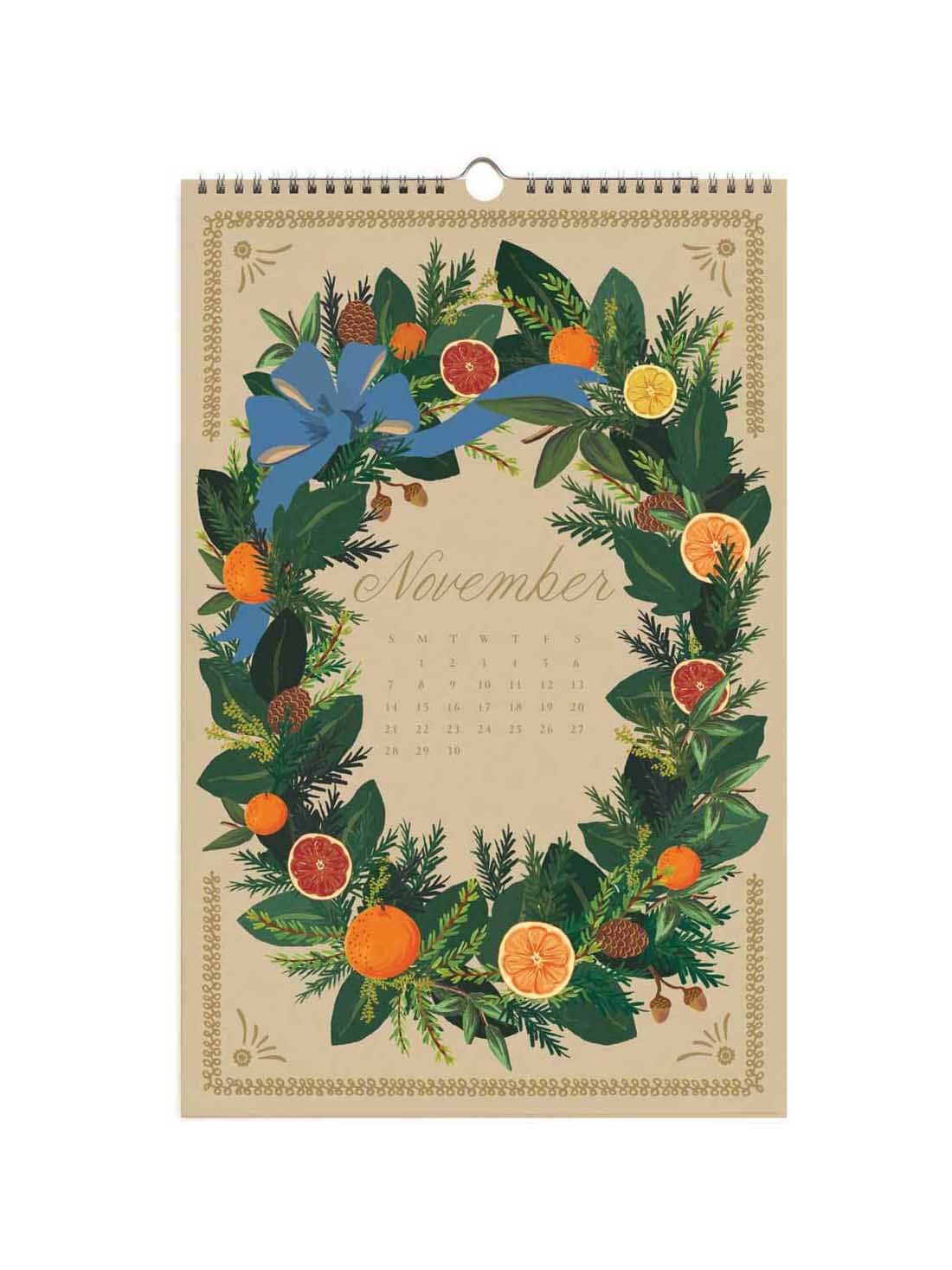 A vintage-style spiral-bound calendar page for November, featuring a botanical wreath illustration with green leaves, blue ribbon, pinecones, and orange slices on a beige background.