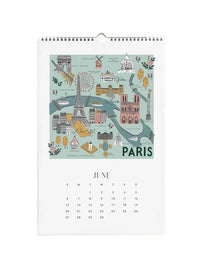 A spiral-bound Paris calendar page showing a colorful illustrated map of Paris landmarks on a mint background, with the word PARIS at the bottom and a June calendar grid below.
