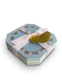 A stack of octagonal mini notepads in a light blue floral pattern
